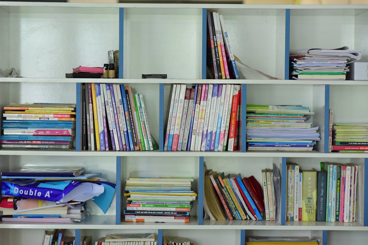Neatly arranged bookshelf containing various educational books and documents.